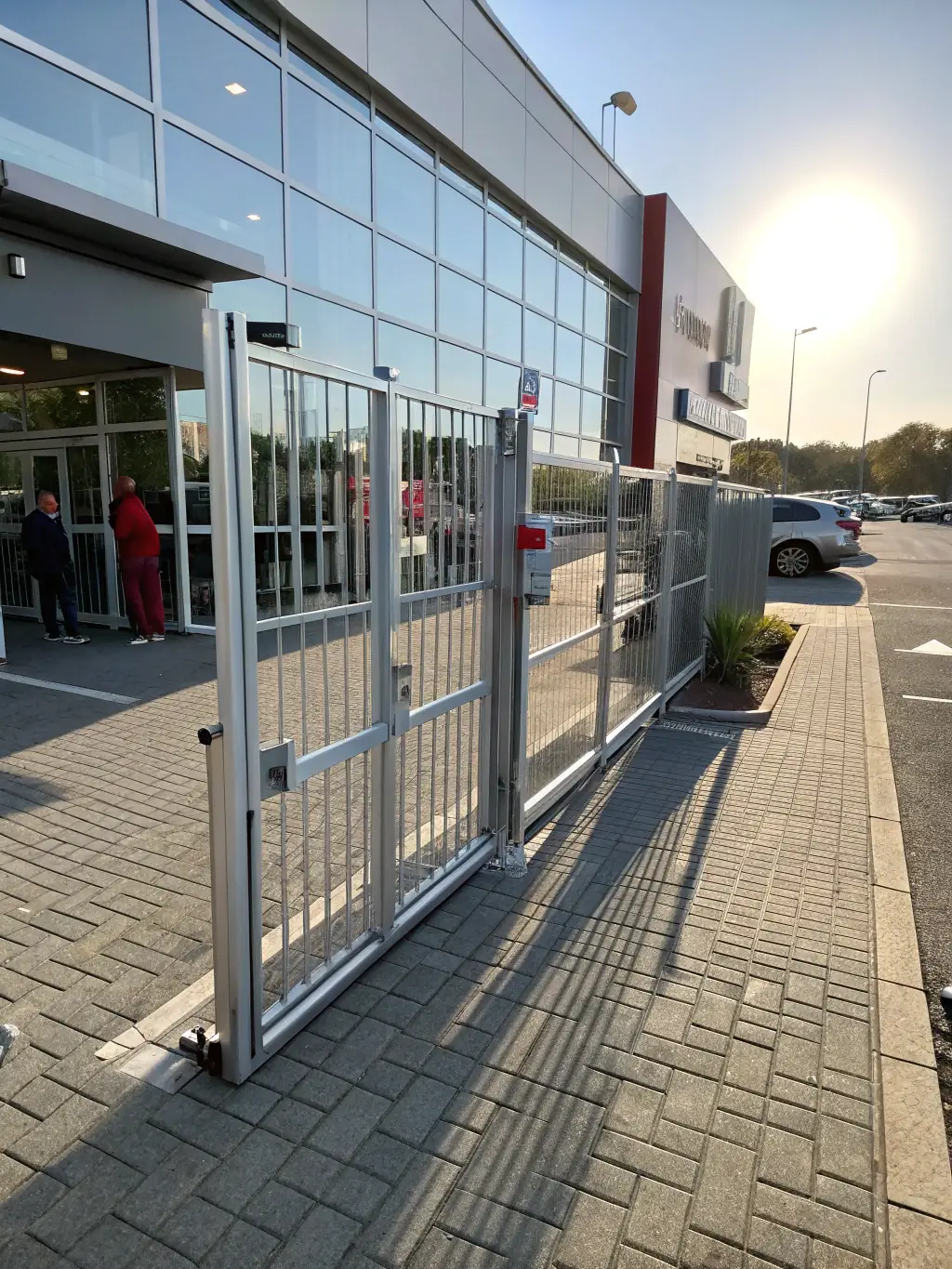 A modern metal gate with intricate designs installed at the entrance of a commercial property, highlighting the security and sophisticated look of RGE Services' custom gate solutions.